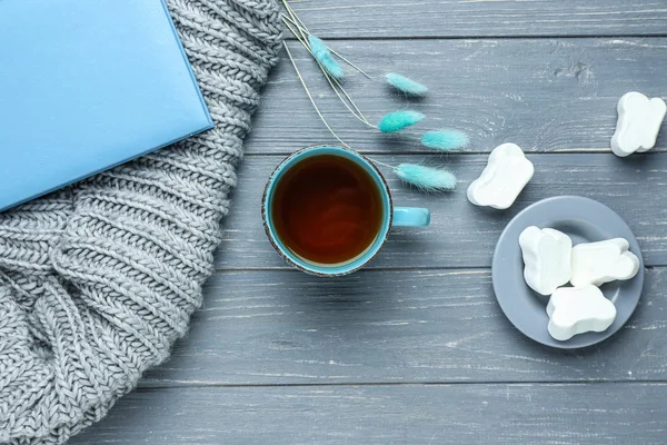 Sammansättning med kopp varmt te, marshmallow och varma Pläd på trä bakgrund — Stockfoto