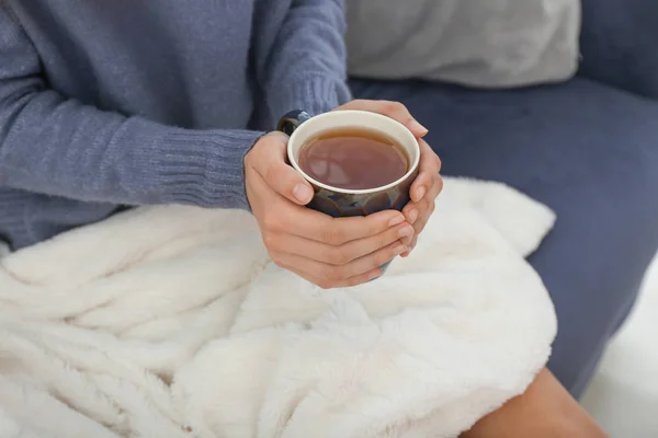 Mujer joven bebiendo té caliente en casa — Foto de Stock