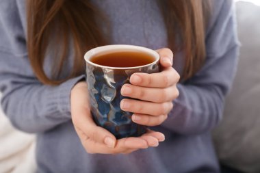 Genç kadın portre evde, sıcak çay içme