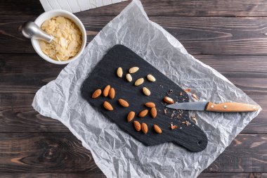 Lezzetli badem ve ahşap masa üzerinde pul ile kayrak plaka