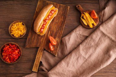 Ahşap masa üzerinde lezzetli sosisli sandviç ile kurulu