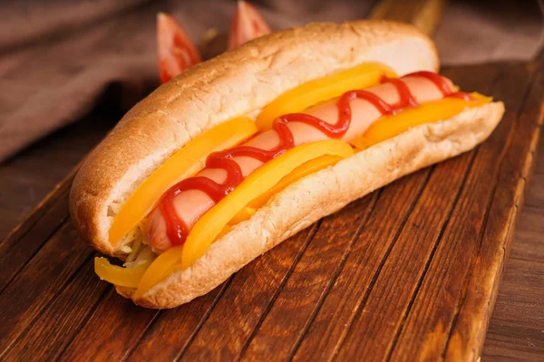 Gustoso hot dog su tavola di legno — Foto Stock