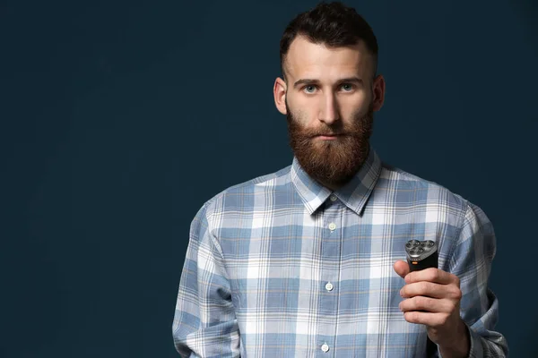 Hombre con afeitadora eléctrica sobre fondo de color — Foto de Stock
