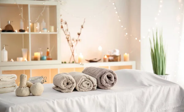 Zachte handdoeken met kruiden zakken op tafel in spa salon — Stockfoto