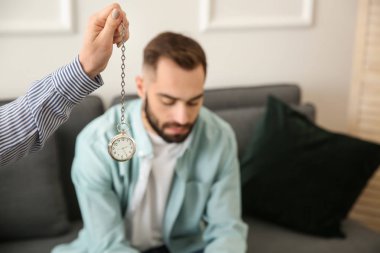Psikolog'ın ofisinde hipnoz oturumu sırasında genç adam