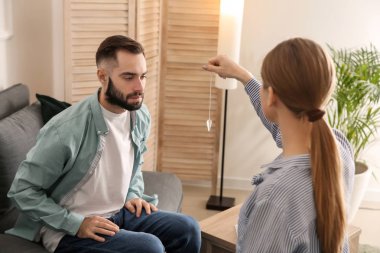 Psikolog'ın ofisinde hipnoz oturumu sırasında genç adam