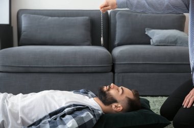 Psikolog'ın ofisinde hipnoz oturumu sırasında genç adam