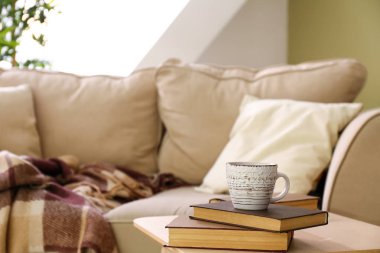 Odada masada sıcak çay ve kitap fincan