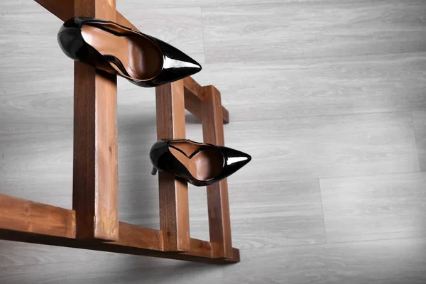 Zapatos femeninos en escalera de madera. Concepto de fracaso profesional — Foto de Stock