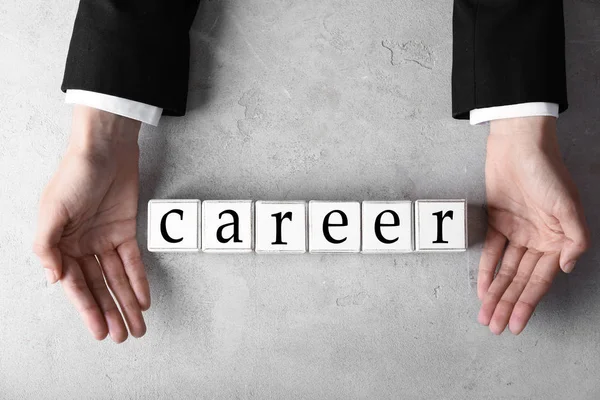 Female hands with word CAREER composed from cubes on light background — Stock Photo, Image