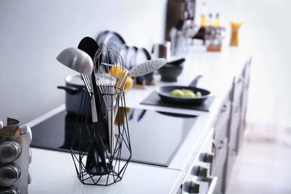 Houder met gebruiksvoorwerpen op teller in de moderne keuken — Stockfoto