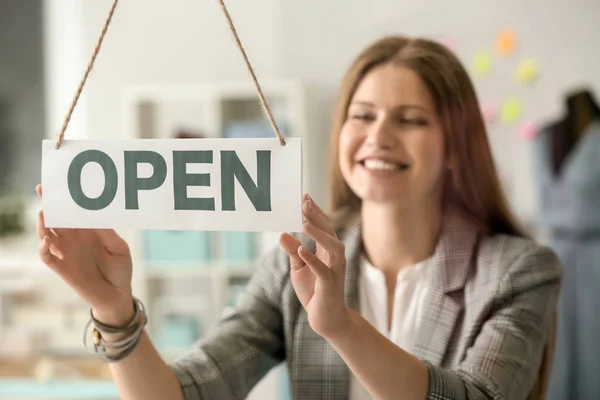 Schöne Geschäftsinhaberin in der Nähe von Eröffnungsschild im Atelier — Stockfoto