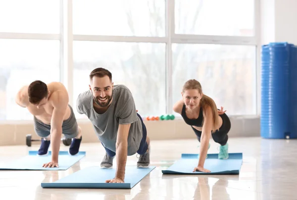 Sporty young people training in gym — Stock Photo, Image