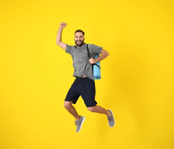 Joven hombre deportivo saltando contra el fondo de color —  Fotos de Stock