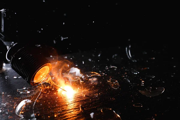 Breaking of light bulb on dark background — Stock Photo, Image