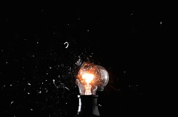 Breaking of light bulb on dark background — Stock Photo, Image