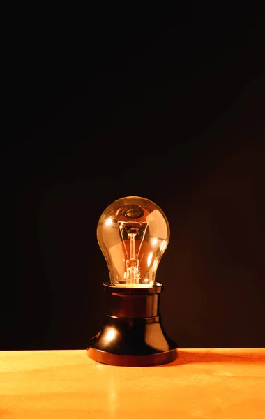 Glowing light bulb on dark background