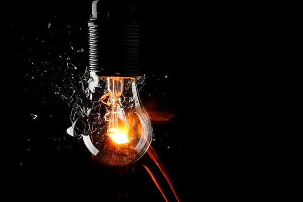 Breaking of light bulb on dark background — Stock Photo, Image