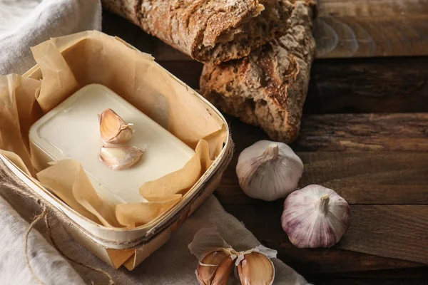 Tasty feta cheese, bread and garlic on wooden background — Stock Photo, Image