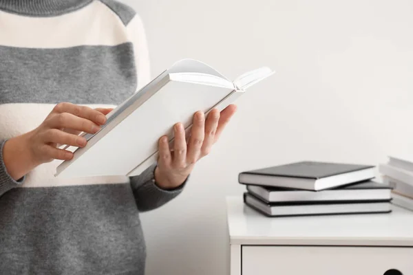 Donna con libro su sfondo chiaro, primo piano — Foto Stock