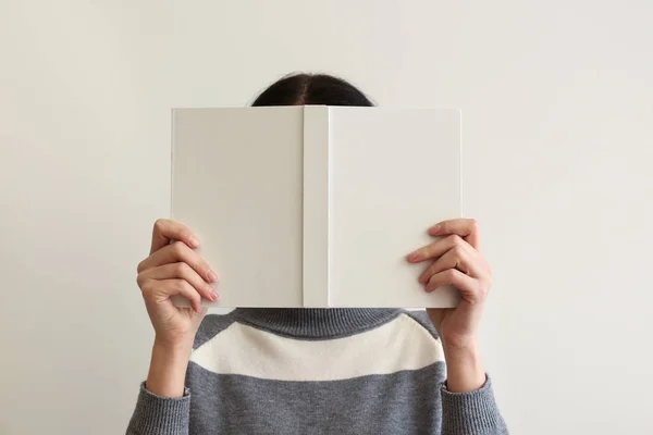 Donna con libro su sfondo chiaro — Foto Stock