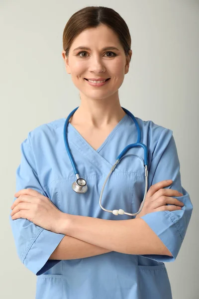Piękna kobieta lekarz na jasnym tle — Zdjęcie stockowe