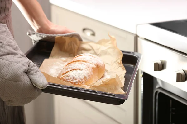 Taking of baking tray with homemade bread out of oven — Stock Photo, Image