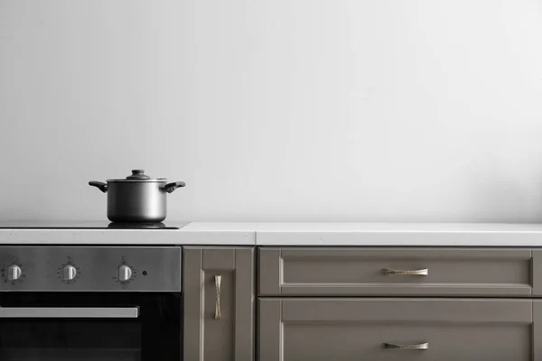 Сотейник на електричній плиті на лічильнику на кухні — стокове фото