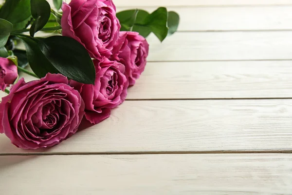 Belles roses sur fond de bois blanc — Photo