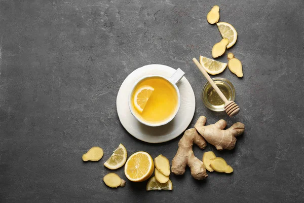 Cup of tasty tea with lemon, ginger and honey on grey background — Stock Photo, Image