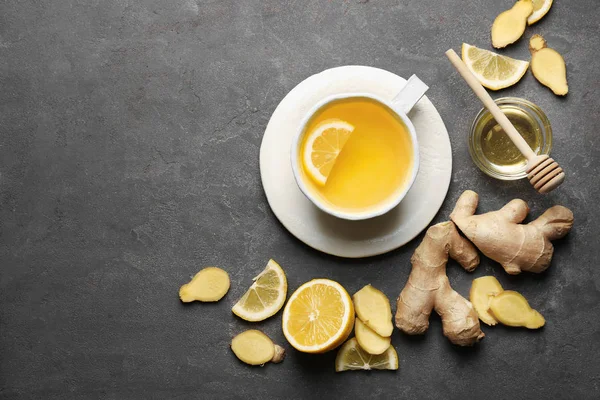Cup of tasty tea with lemon, ginger and honey on grey background — Stock Photo, Image