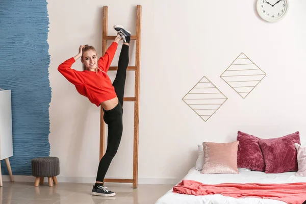 Jonge vrouwelijke danseres die zich thuis uitstrekt — Stockfoto