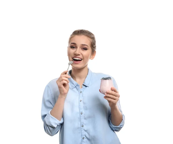 Junge Frau isst leckeren Joghurt auf weißem Hintergrund — Stockfoto