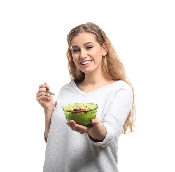 Mujer joven comiendo sabroso yogur sobre fondo blanco — Foto de Stock