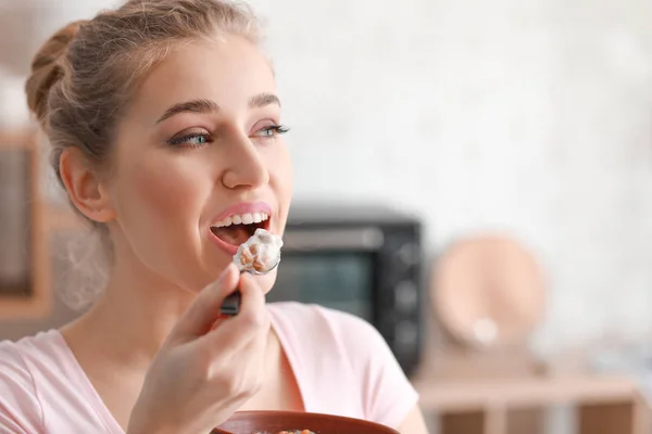 Giovane donna mangiare gustoso yogurt a casa — Foto Stock