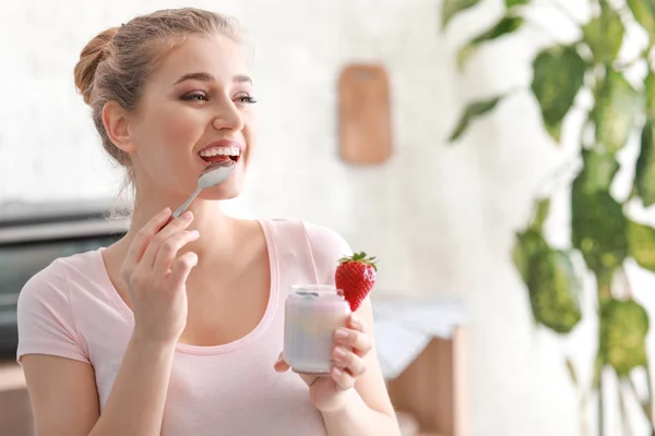 Ung kvinna äta läckra yoghurt hemma — Stockfoto