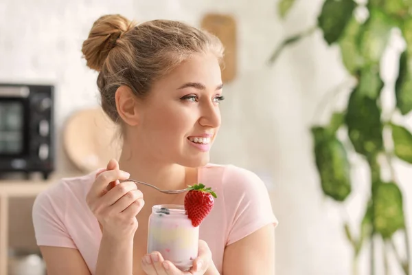 Jovem mulher comendo iogurte saboroso em casa — Fotografia de Stock