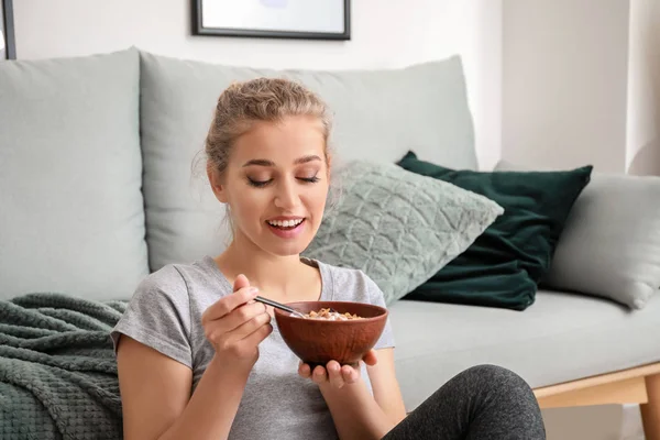 Desportivo jovem mulher comer iogurte saboroso em casa — Fotografia de Stock