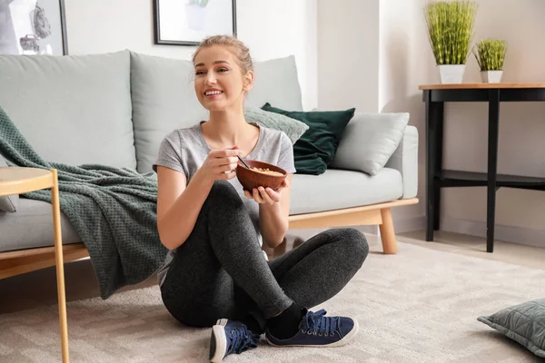 Desportivo jovem mulher comer iogurte saboroso em casa — Fotografia de Stock