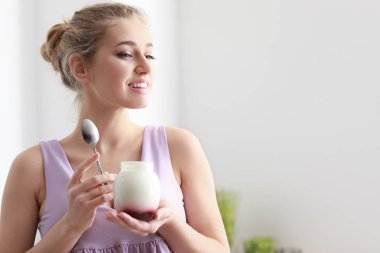 Genç kadın lezzetli yoğurt evde yemek