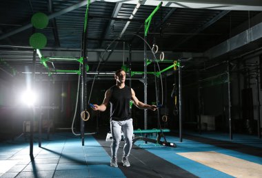 Spor salonunda bir halat atlama genç sportif adam