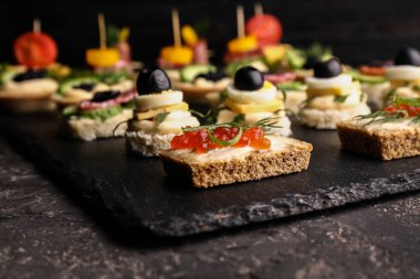 Koyu masada lezzetli kanepeler ile Slate plaka, çekim