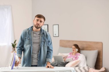 Karısını yatakta çalışma sırasında elbise Ütü househusband