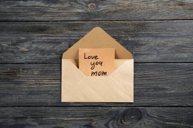 Zarf ile ahşap arka plan üzerinde anneler günü için tebrik kartı