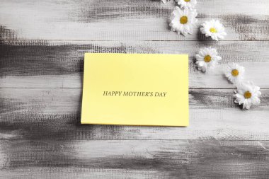 Ahşap arka plan üzerinde anneler günü için tebrik kartı