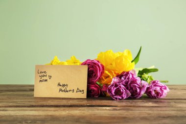 Ahşap masada güzel çiçekler ile anneler günü için tebrik kartı