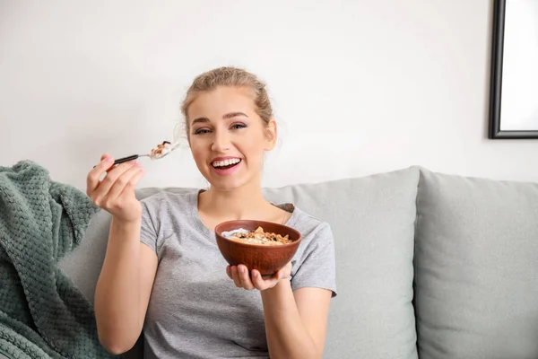 Young woman eating tasty yogurt at home — Stock Photo, Image