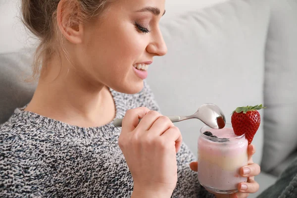 Mujer joven comiendo sabroso yogur en casa — Foto de Stock