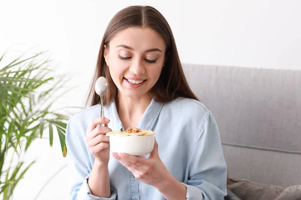 Mujer joven comiendo sabroso yogur en casa — Foto de Stock
