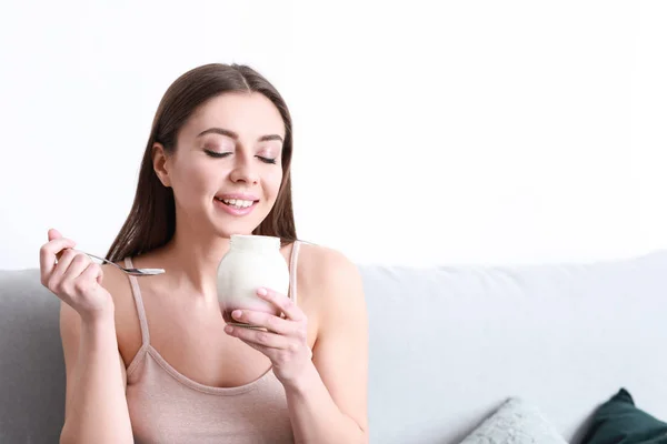 Young woman eating tasty yogurt at home — Stock Photo, Image